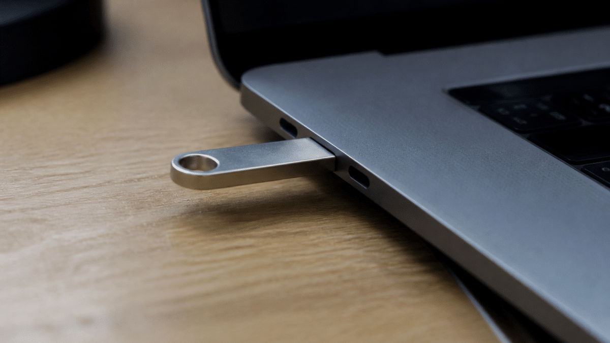Main tenant clé USB connectée à port Mac horizontalement