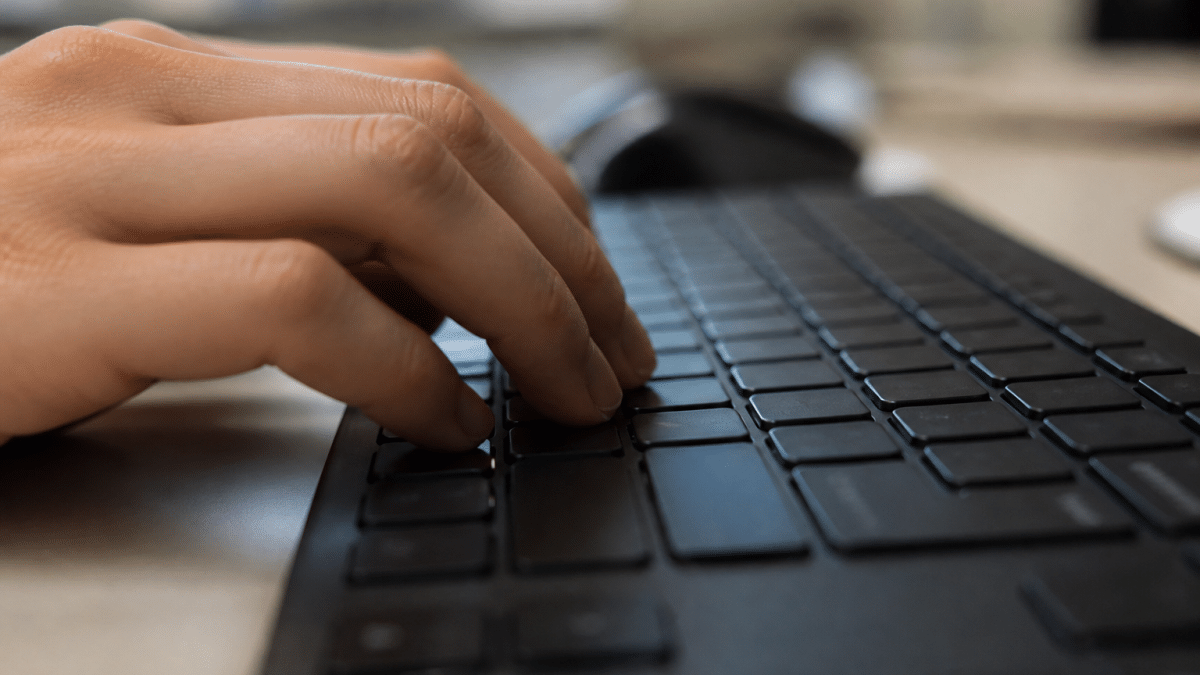 Doigts appuyes sur touches clavier pour inscrire symbole monetaire