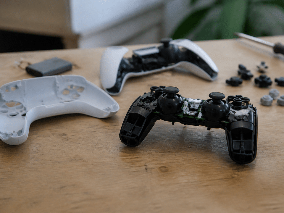 Manette PlayStation 5 demontee posee sur etabli de reparation