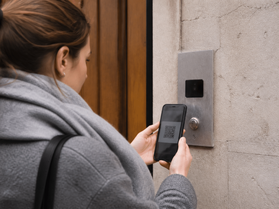 Personne tenant telephone face ecran affichant code carre