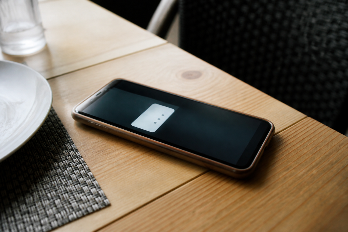 Smartphone sur table montrant un menu avec trois points
